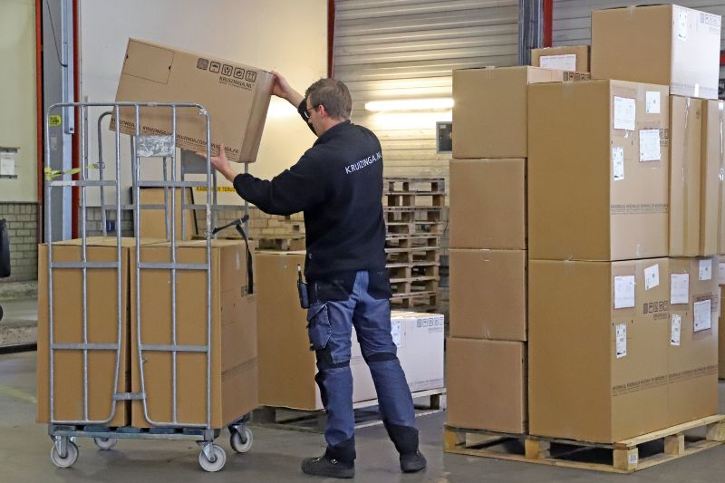 orderpicken magazijnmedewerker met dozen op rolcontainer